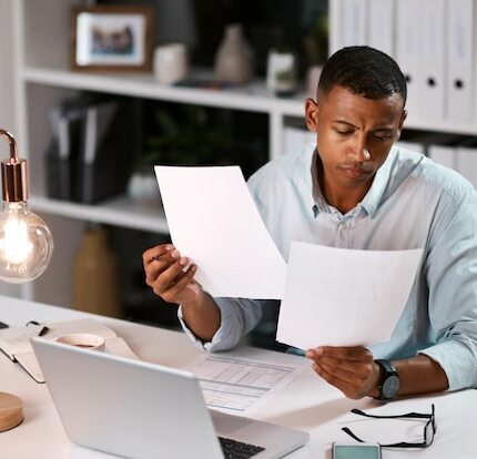 night-man-home-office-with-documents-laptop-paperwork-desk-deadline-overtime-as-accountant-male-person-remote-work-entrepreneur-with-company-financial-report-statement-normal
